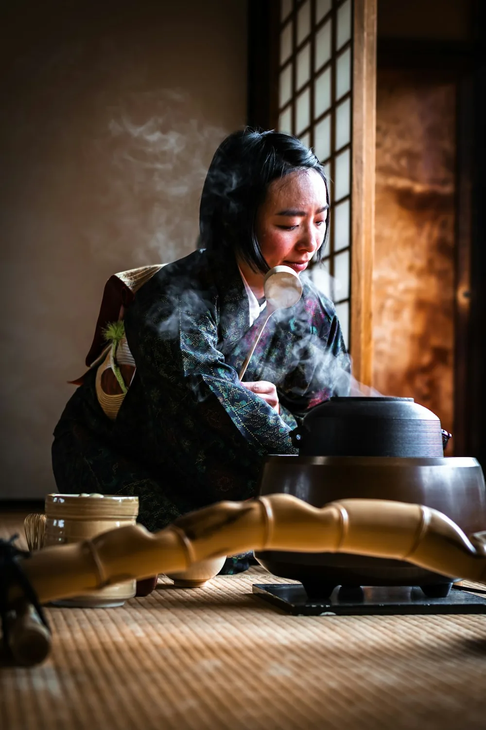 炉の前で湯を扱う着物姿の女性
